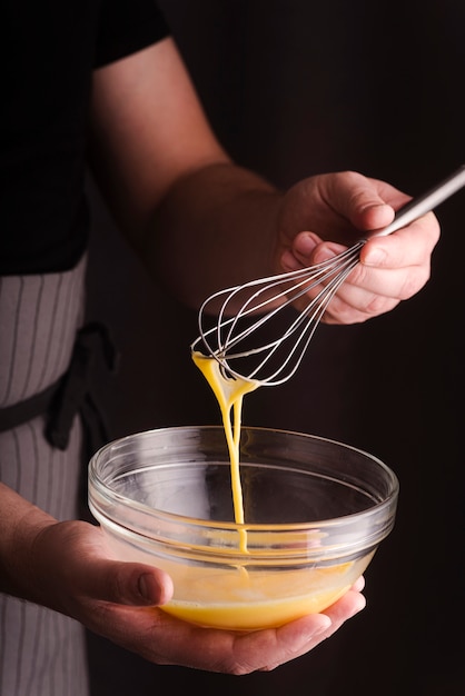 Cook whisking eggs in bowl