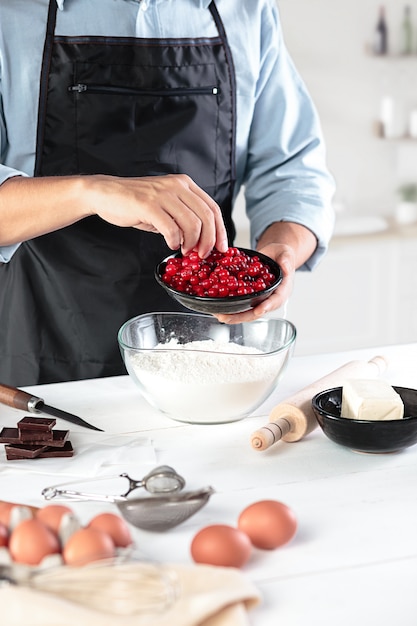 A cook with eggs on a rustic kitchen against the background of men's hands