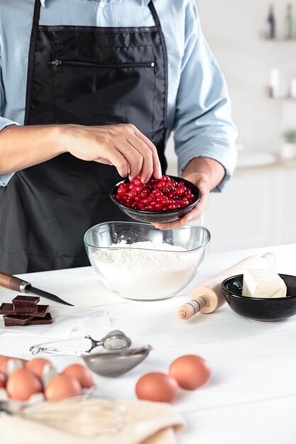 A cook with eggs on a rustic kitchen against the background of men's hands