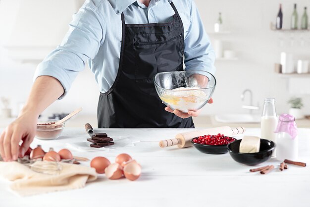 cook with eggs on a rustic kitchen against the background of men's hands