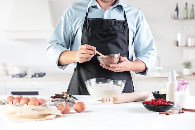 A cook with eggs on a rustic kitchen against the of men's hands