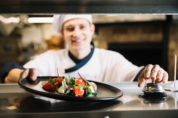 Cook with salad ringing service bell 