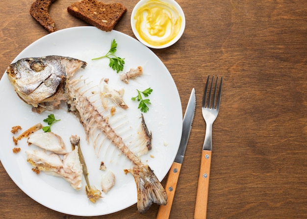 調理済みの魚の残り物とカトラリー