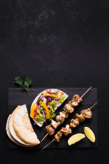 Cooked meat and veggies kebab on black table