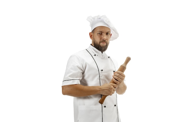 Cooker, chef, baker in uniform isolated on white studio background, gourmet. Young man, restaurant cooker's portrait. Business, foor, professional occupation, emotions concept. Copyspace for ad.