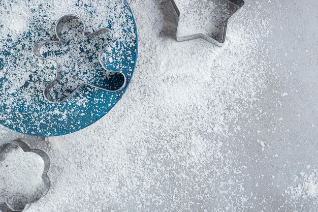 Cookie molds, platter and coconut powder on marble table.