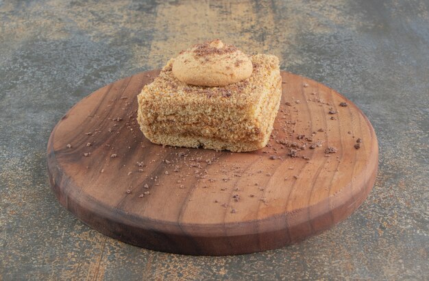 Cookie on a slice of cake on a board 