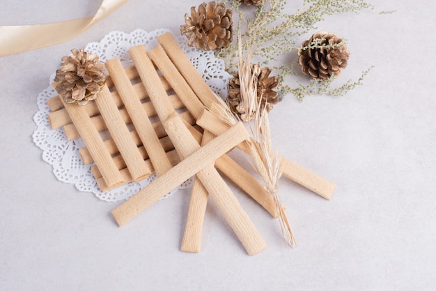 Cookie sticks with pinecone on white surface