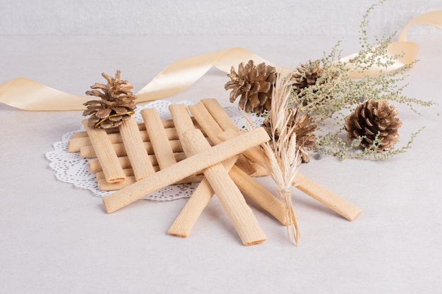 Cookie sticks with pinecone on white table