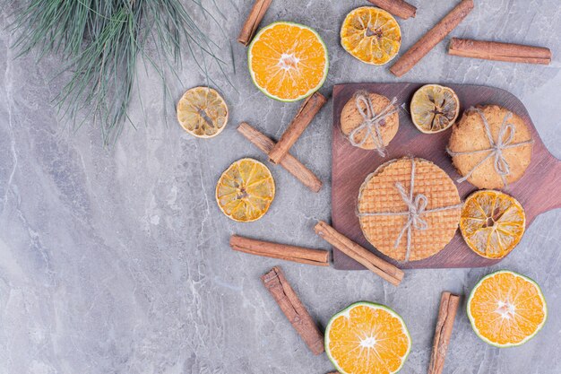 Cookie varieties on a wooden board with cinnamon and oranges