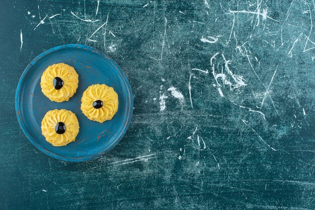 Cookie with chocolate on a wooden plate , on the blue background. High quality photo