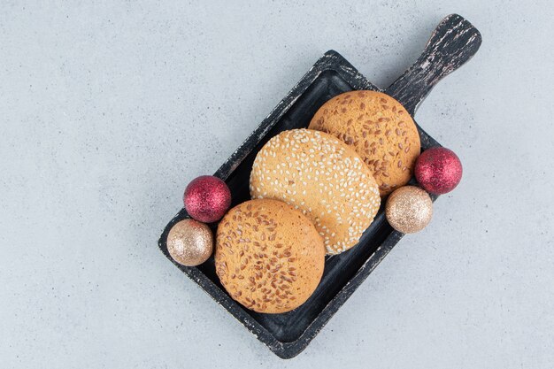 Cookies and baubles on a small tray on marble background.