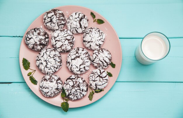 Cookies on blue wooden table in a plate with glass of milk