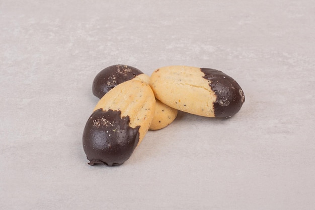 Cookies decorated with chocolate sauce on white surface.