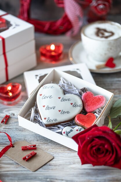 나무 테이블에 빨간 리본으로 선물 상자에 쿠키 또는 진저 쿠키. 발렌타인 데이.