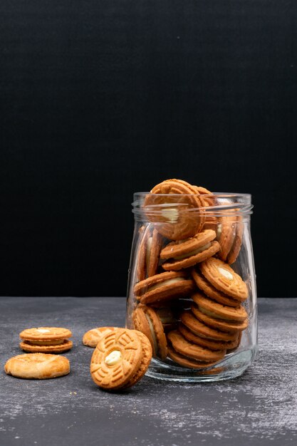 Cookies in a glass jar on dark surface