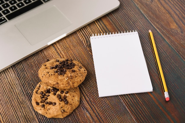 Cookies near notebook and laptop