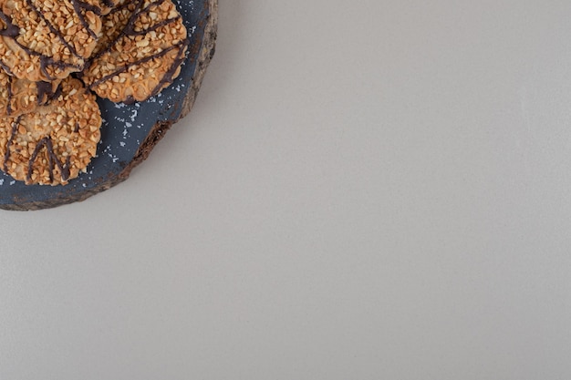 Cookies piled up on a wooden board on marble background.