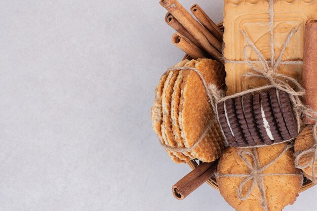 Cookies in rope with cinnamon on white surface
