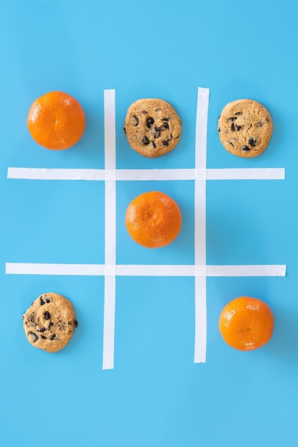 Cookies and tangerines on a blue background flat lay