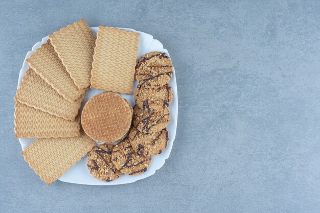 Cookies and waffles on white plate. Top view of fresh cookies.