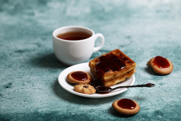 Cookies and a white cup of tea.