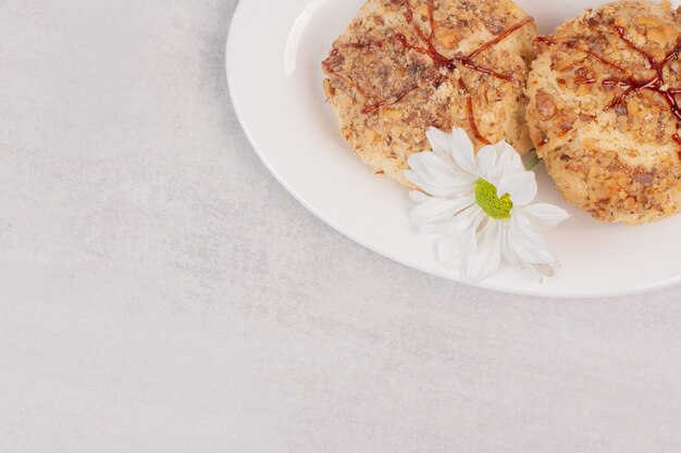 Cookies with caramel sauce and flower on white.