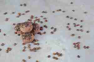 Free photo cookies with chocolate chip topping and scattered coffee beans on marble table.