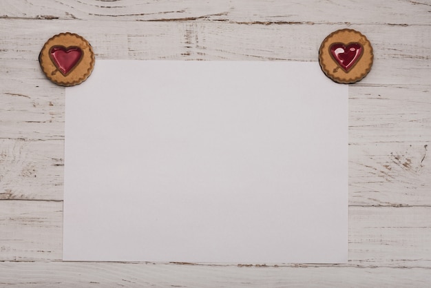 Biscotti con un cuore negli angoli di una carta bianca