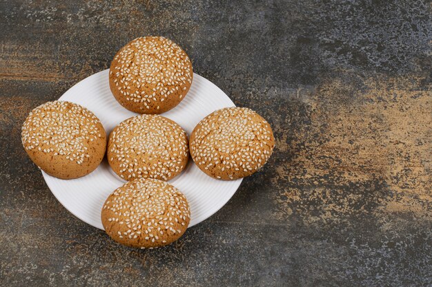 Cookies with sesame seeds on white plate. 