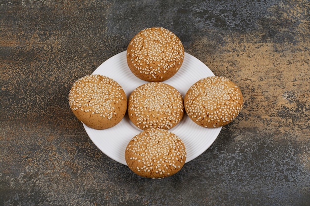 Biscotti con semi di sesamo sulla zolla bianca.