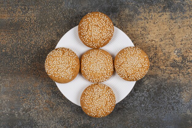 Cookies with sesame seeds on white plate. 