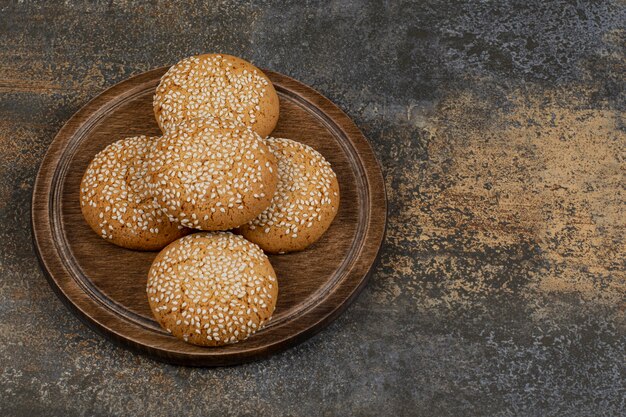 Cookies with sesame seeds on wooden board. 