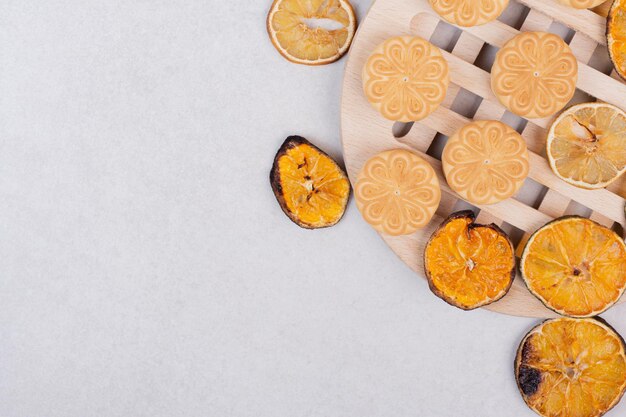 Печенье с дольками апельсина на деревянной тарелке