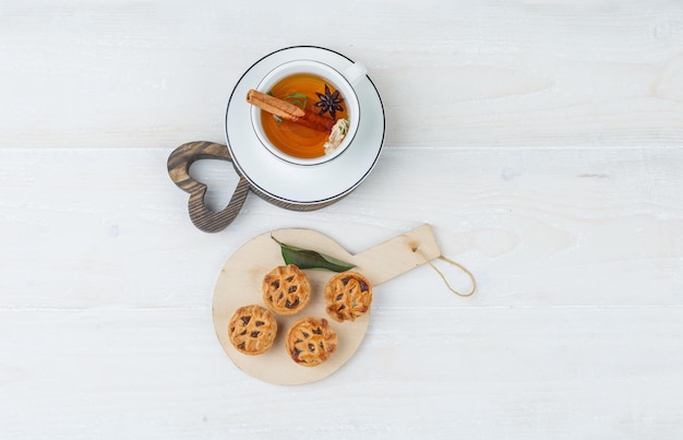 Free photo cookies on a wooden board with a cup of tea
