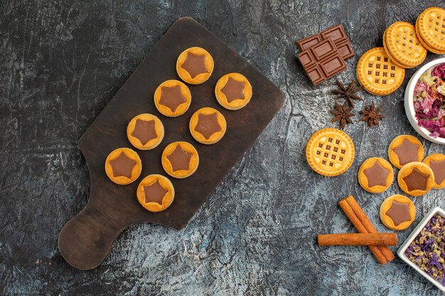 cookies on wooden platter and dry flowers on grey