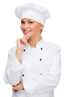 Концепция кулинарии и еды - мечтающая улыбающаяся женщина-повар, повар или пекарь