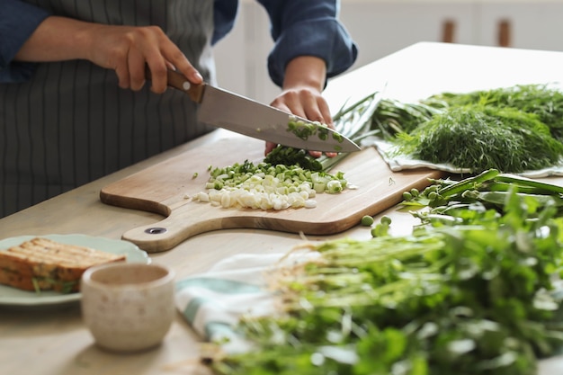 Free photo cooking. chef is cutting greens in the kitchen