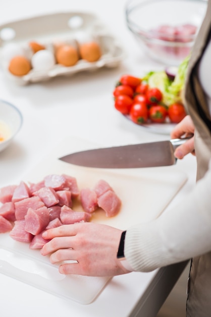 Banco di cottura con cuoco in piedi con coltello