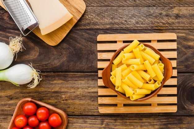 Cooking ingredients and grater near pasta