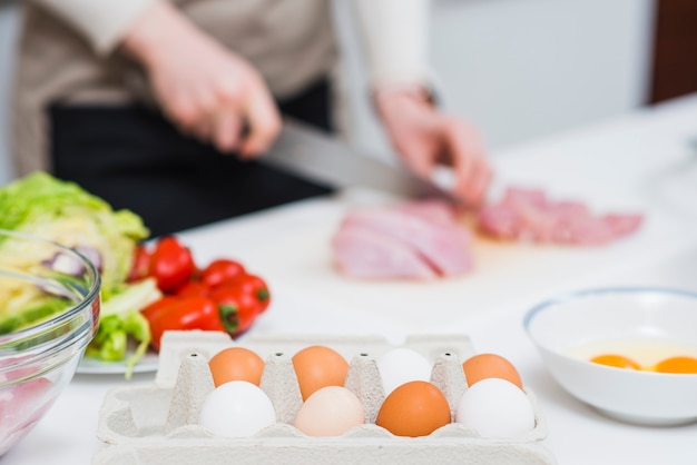 Cooking table with ingredients and person preparing food