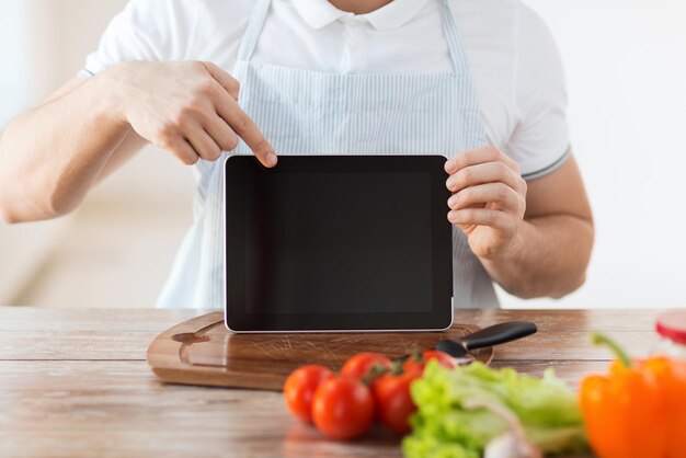 Кулинария, технологии, реклама и домашняя концепция - крупный план мужских рук, держащих планшетный компьютер с пустым черным экраном и указывающих на него