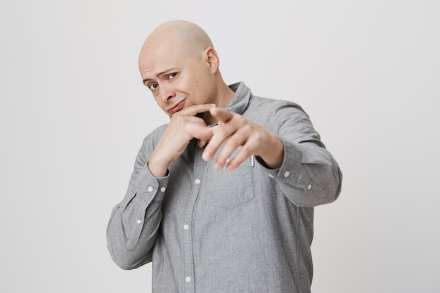 Free photo cool bald guy pointing finger at front