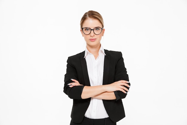 Cool blonde business woman in eyeglasses posing with crossed arms over white