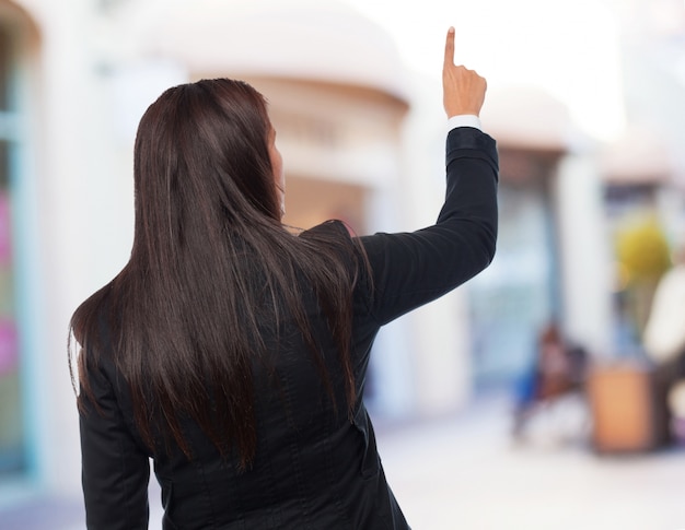 Free photo cool business-woman pointing up