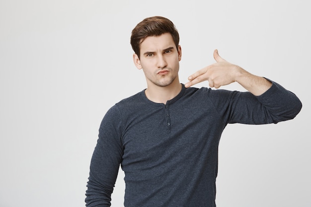 Free photo cool confident guy showing gun gesture
