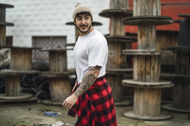 Cool European bearded male with arm tattoos casually dressed looking back