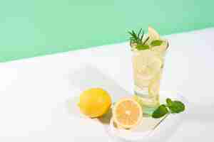 Free photo cool freshly made lemonade ice cubes and lemon fruits on white table background