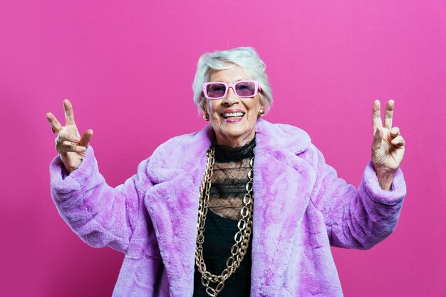 멋진 옷을 입고 스튜디오에서 포즈를 취하고 파티를 하는 멋진 할머니 프리미엄 사진
