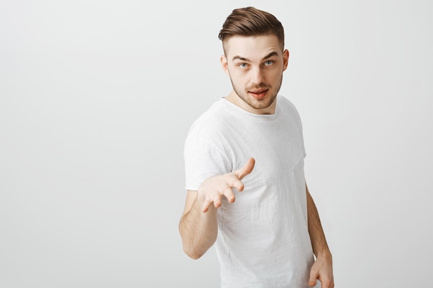 Cool and handsome young man pointing as talking, teaching lesson